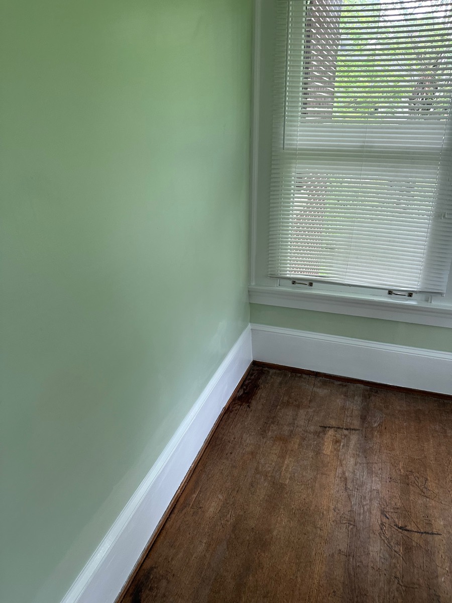 Bedroom after painting — smooth sage green walls with crisp white trim