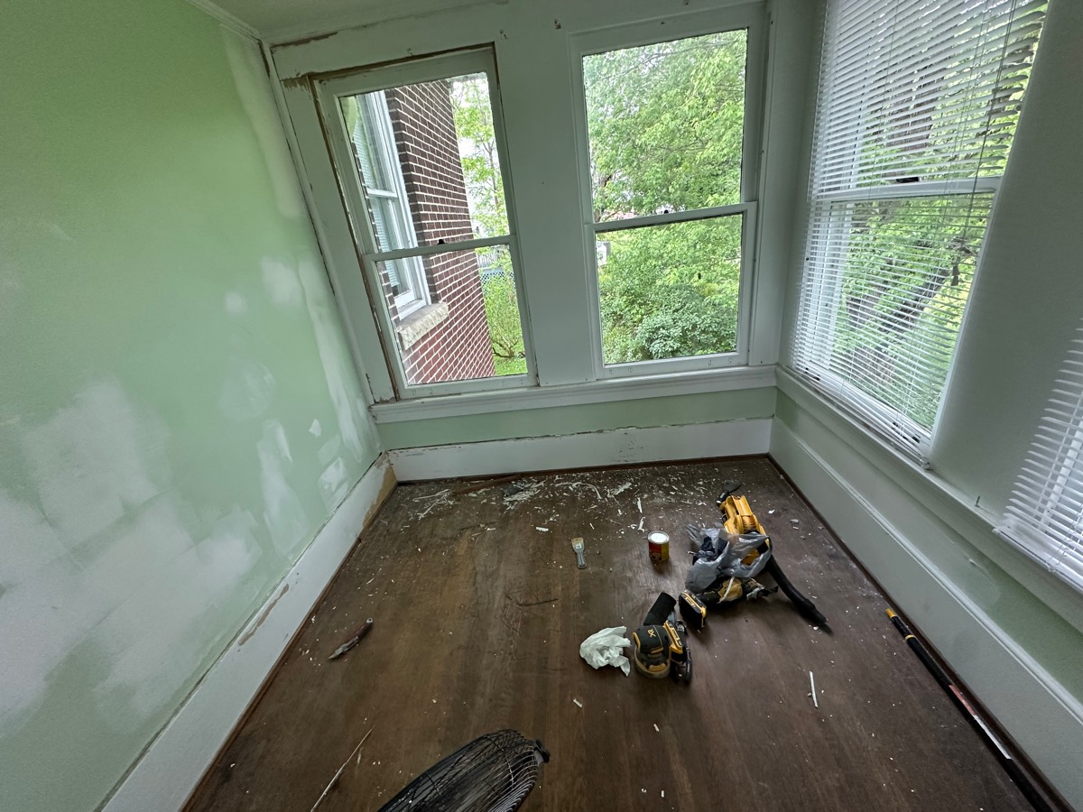 Bedroom before painting — patched and primed walls, bare floor