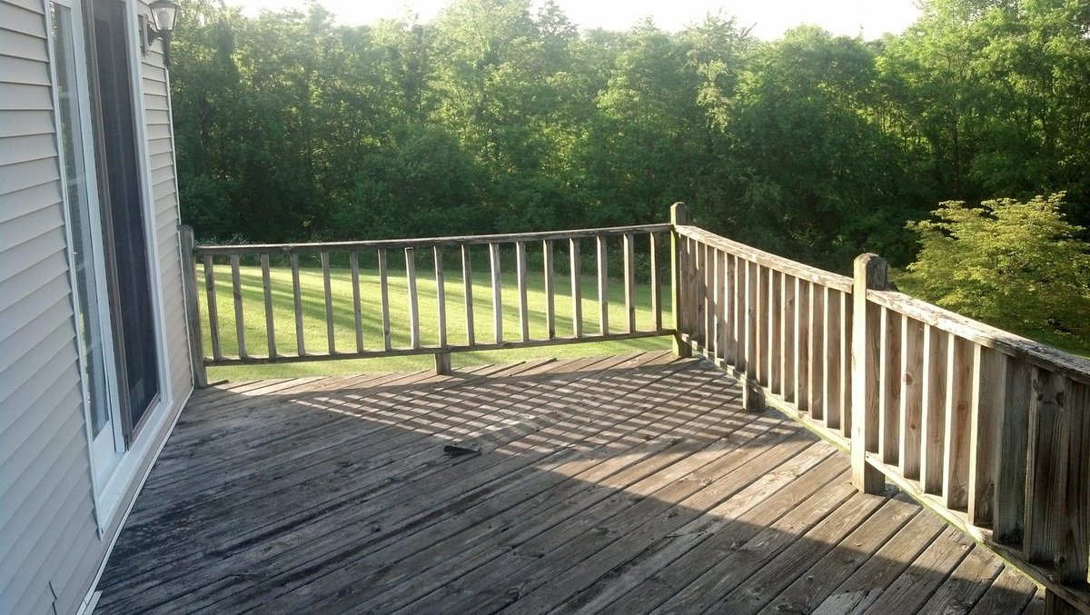 Deck before rebuild — weathered boards and worn wood railing