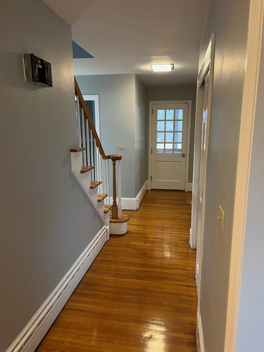 Hallway and staircase after painting — gray walls, crisp white trim