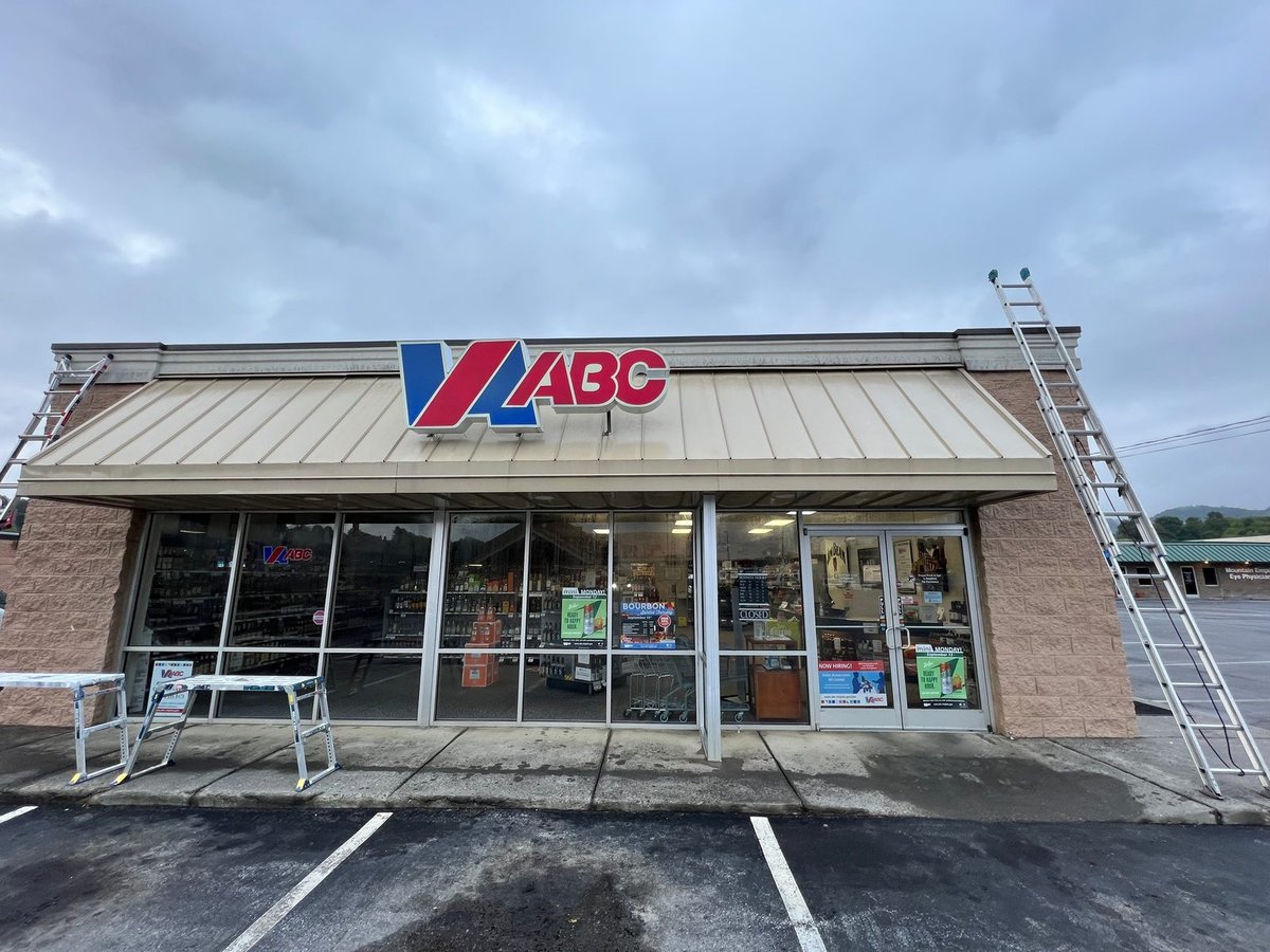 Retail storefront before repaint — tan stucco walls and tan metal awning